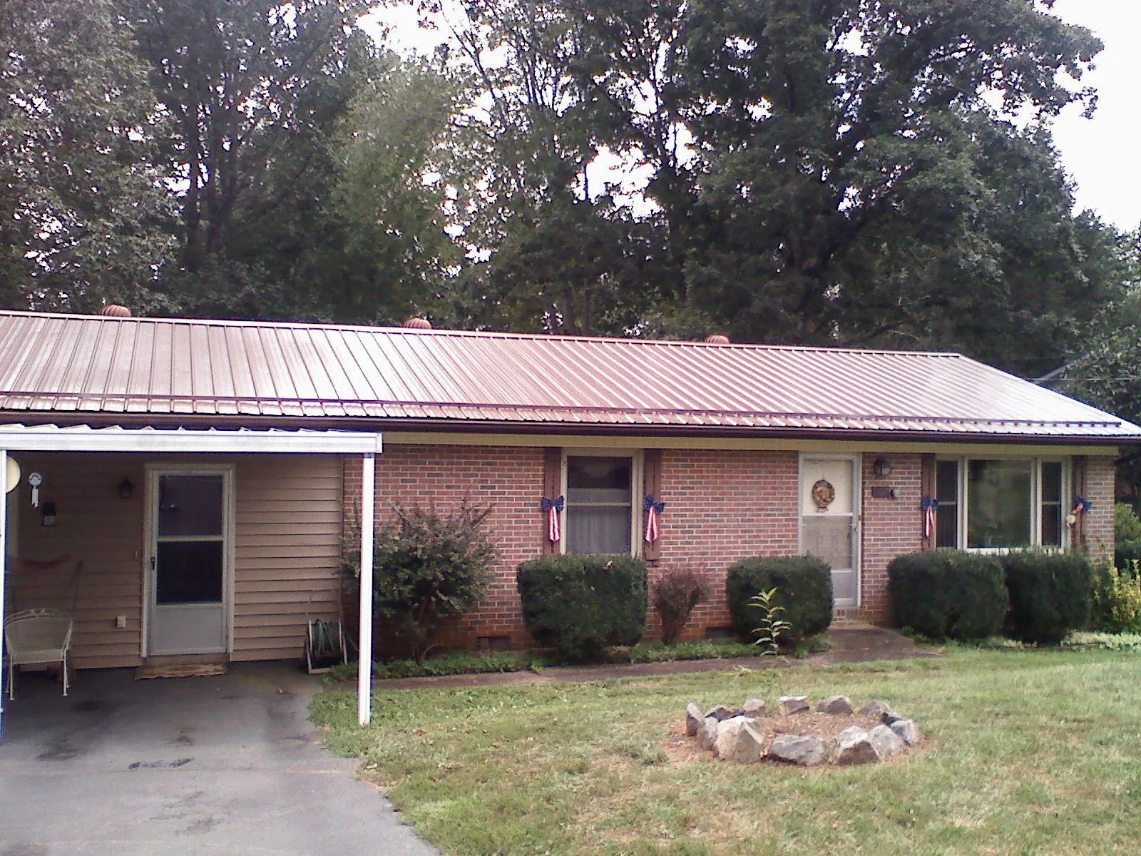 Bronze metal roof and carport on a brick ranch home — Roof Repair work by our crew in Waterbury